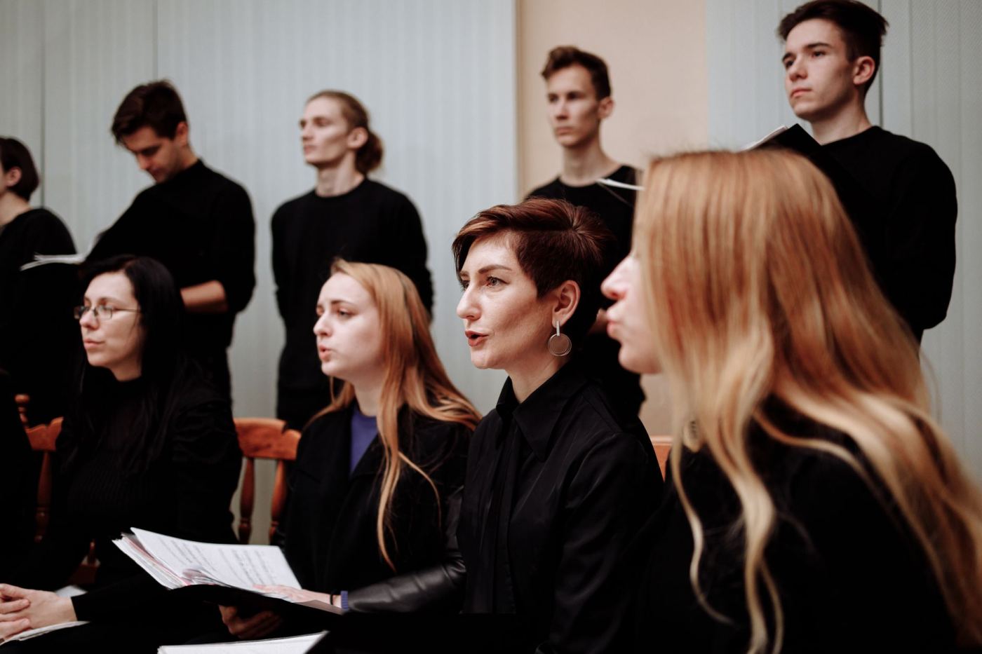 Un groupe de jeunes chanteurs répète, partitions en main