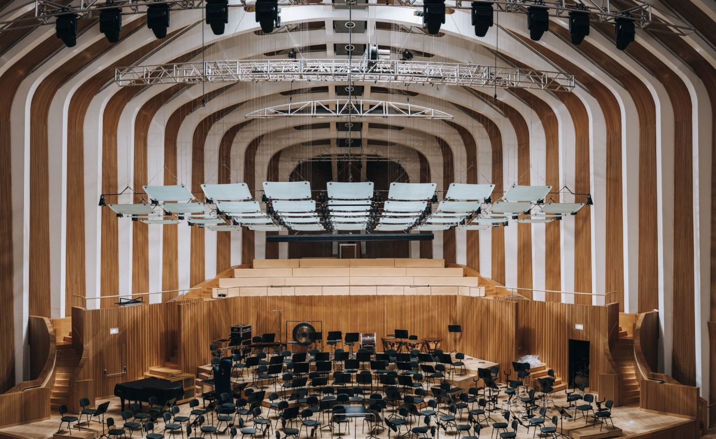 Une grande salle de concert vue depuis la scène, orchestre installé