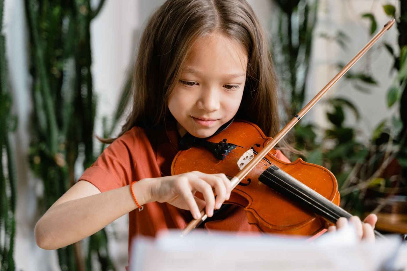 Une enfant joue du violon pendant un atelier musical
