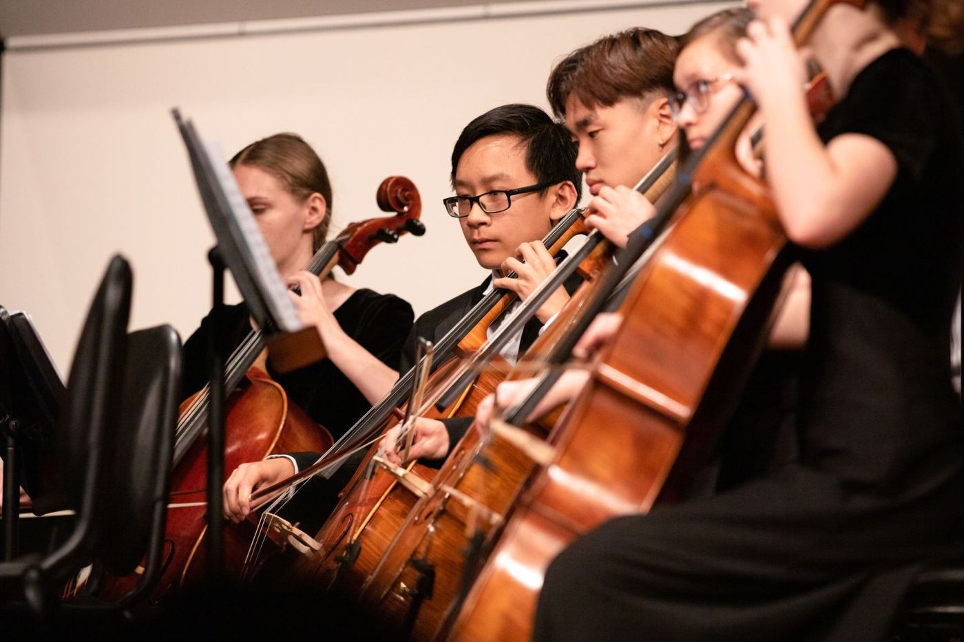 De jeunes musiciens jouent dans un orchestre, un violoncelliste au premier plan