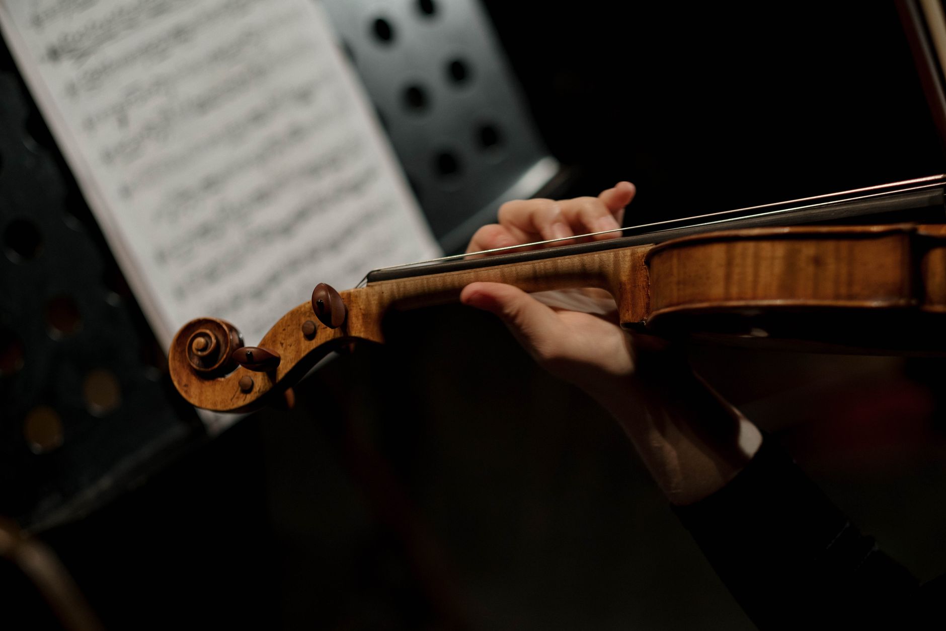 Un violoniste en pleine interprétation, mettant en valeur la main gauche avec grâce et précision.
